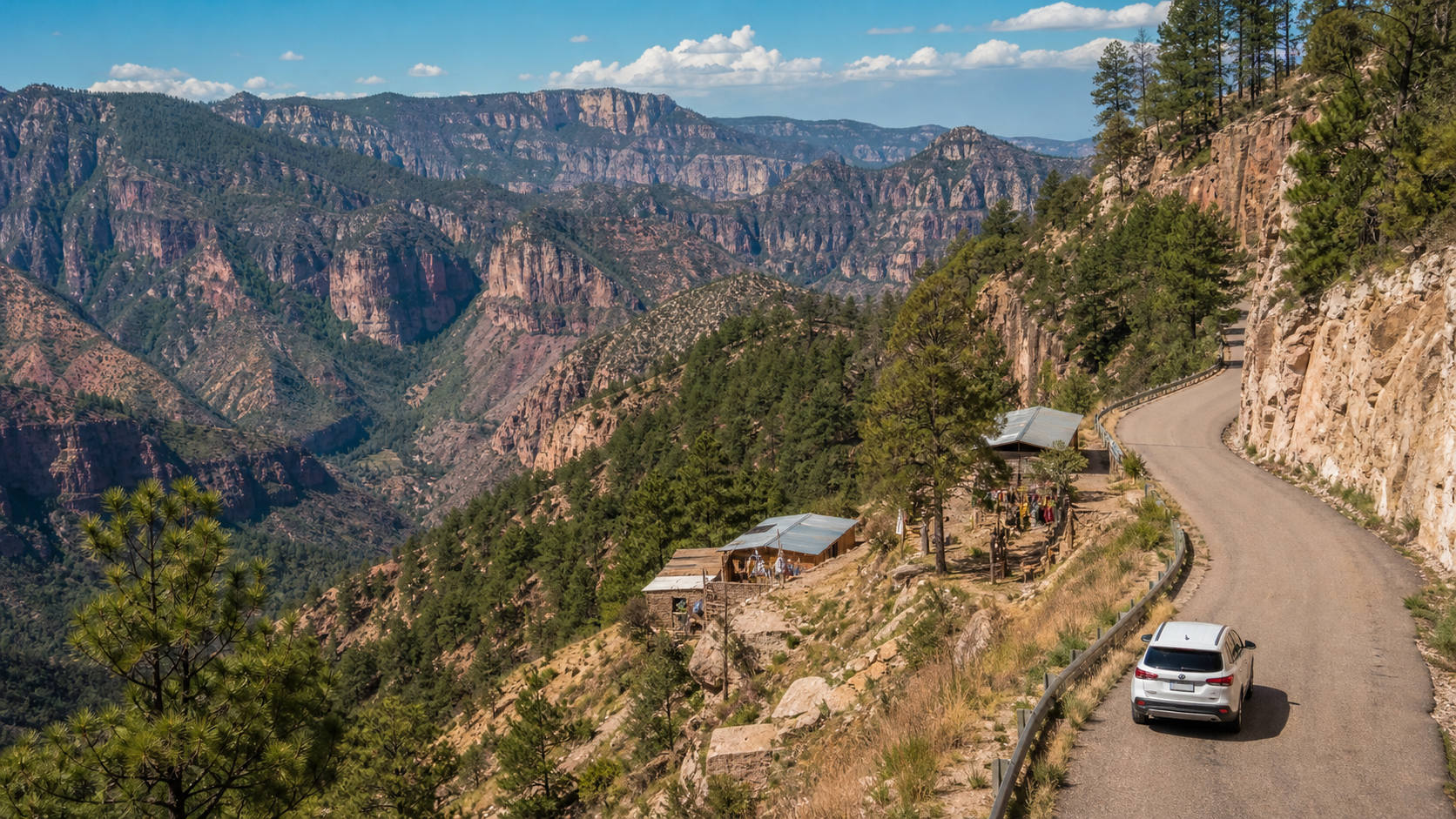 Paisaje de las Barrancas del Cobre en la Sierra Tarahumara con carretera escénica entre montañas.