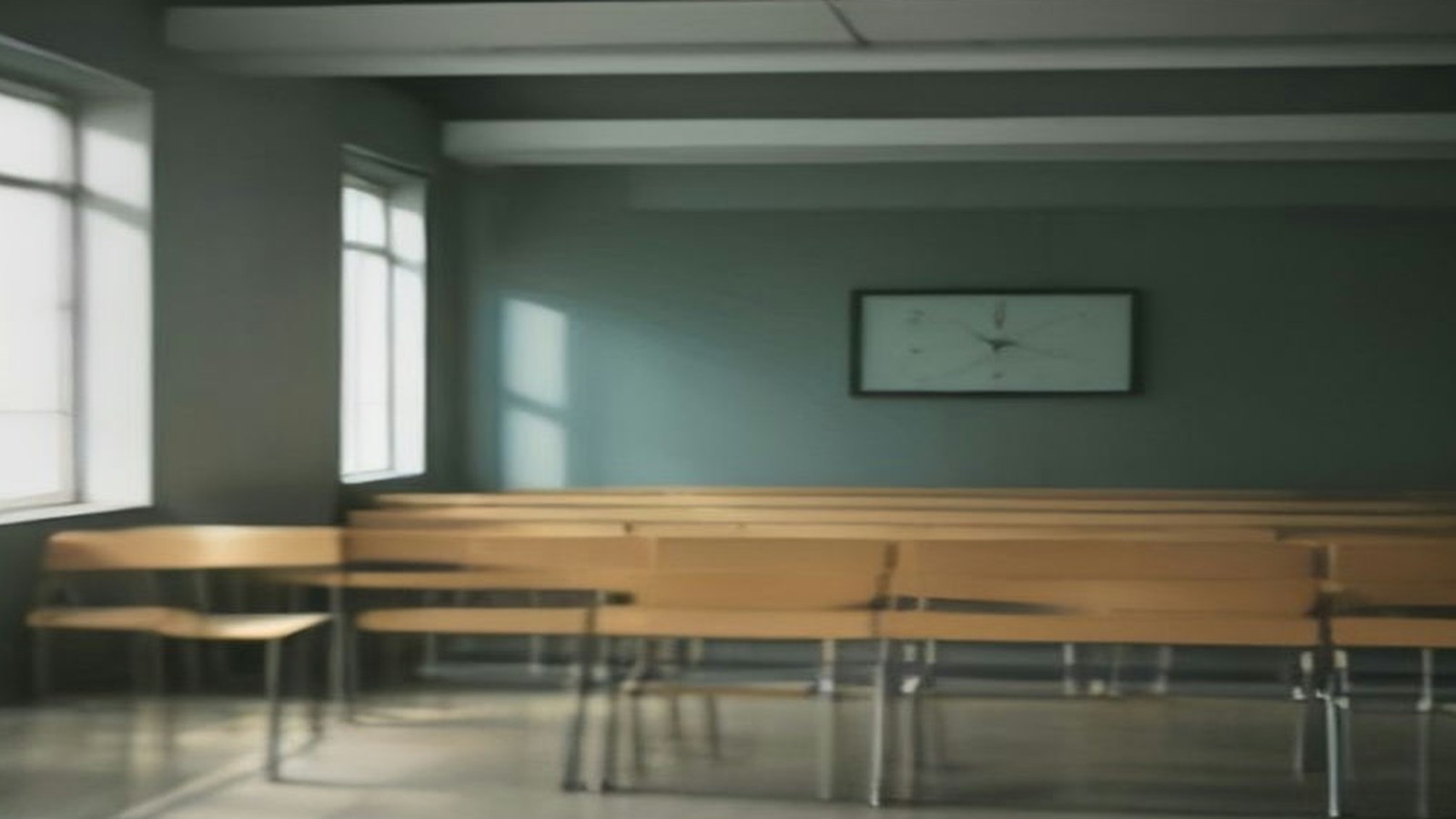 Sala de espera con bancas de madera vacías y un reloj de pared sobre un muro verde grisáceo